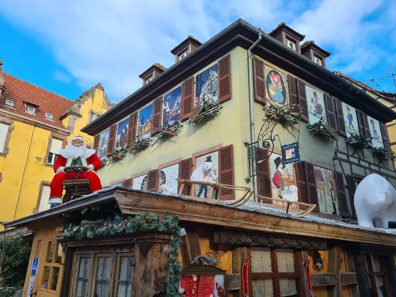 La façade de la Krutenau décorée pour Noël, avec son enseigne en fer forgé